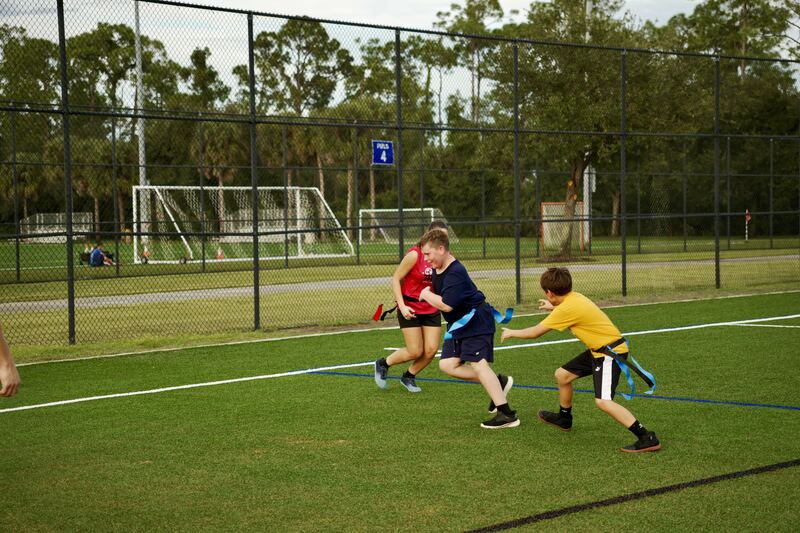 Three athletes competing in a flag tag game
